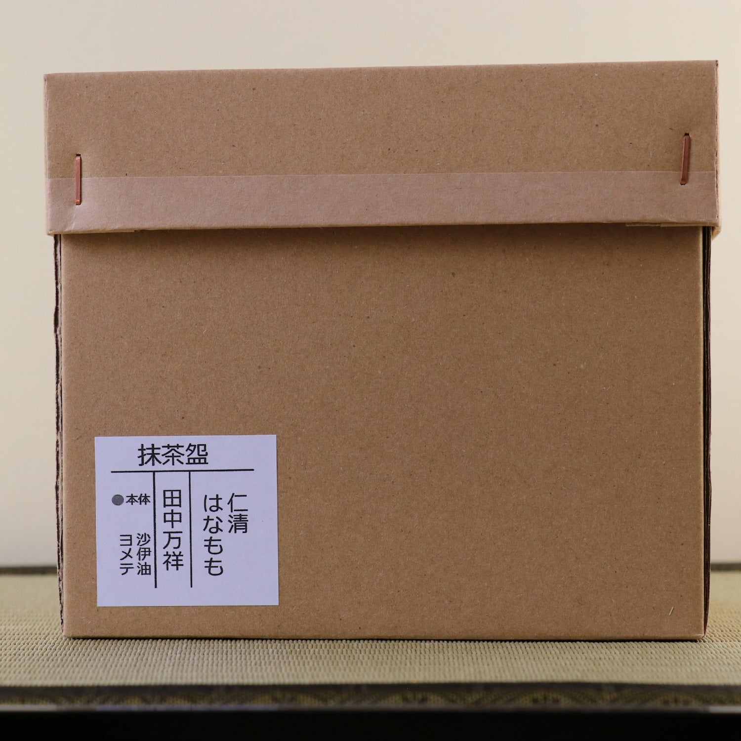 Brown cardboard box with a white label on a wooden surface
