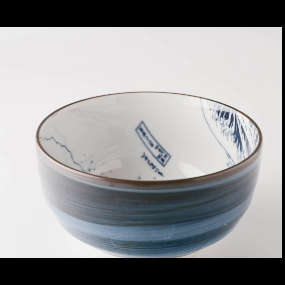 A ceramic bowl with a blue and white hand-painted wave design and brushstroke texture, photographed on a clean white background.