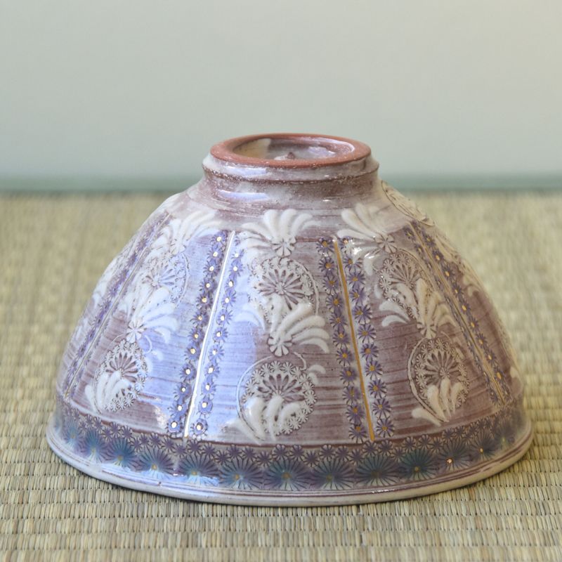 Ceramic bowl with floral patterns on a woven surface