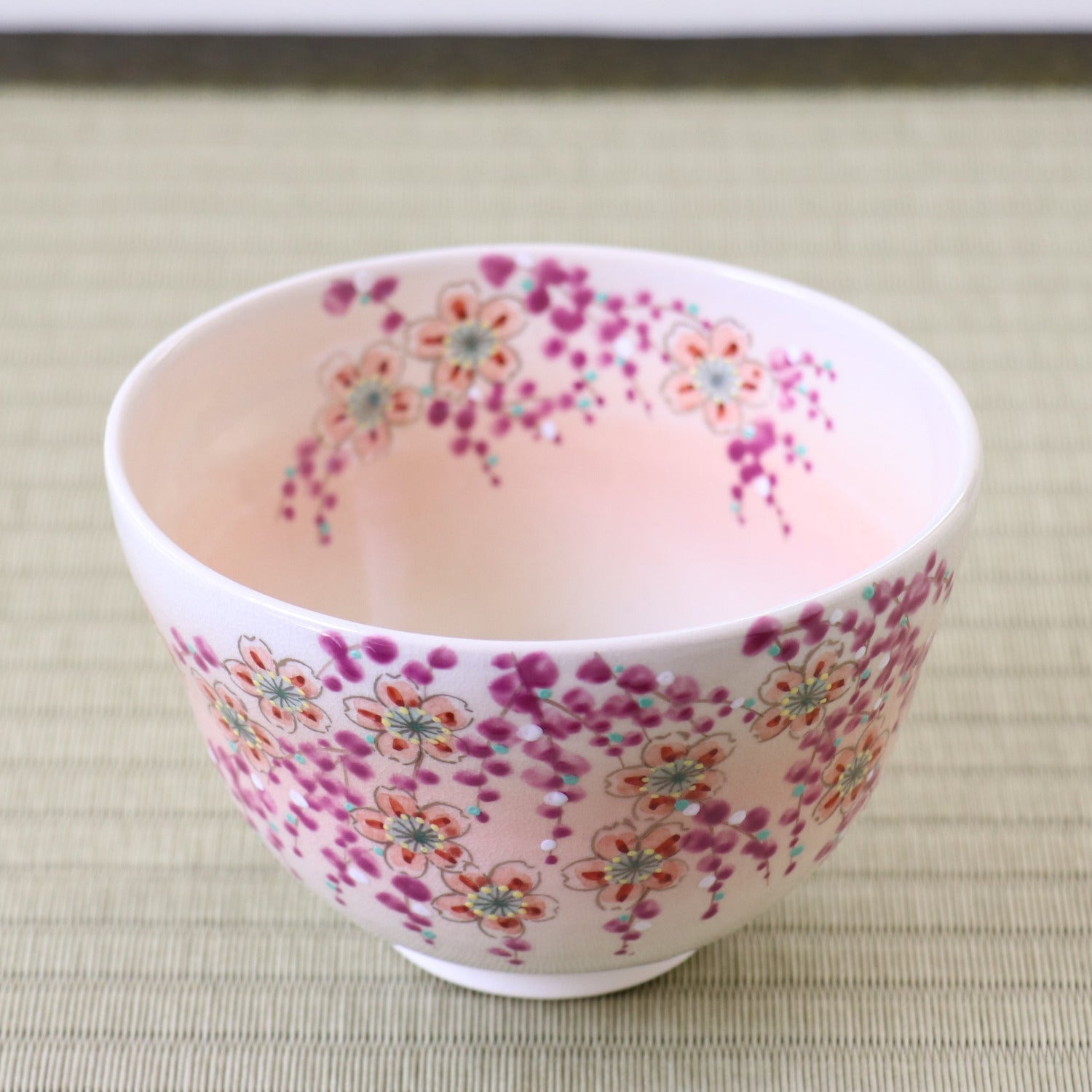 Small ceramic cup with floral pattern on a light wooden surface