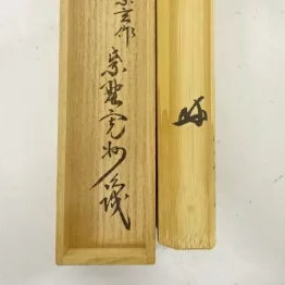 Two wooden sticks with engraved text on a white background