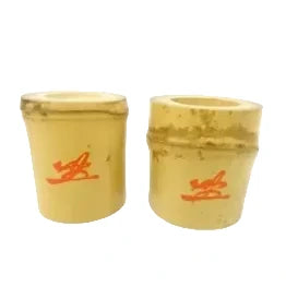 Two yellow cups with red designs on a white background