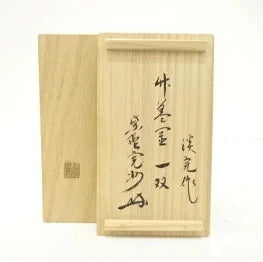 Wooden box with Japanese text and a seal on a white background