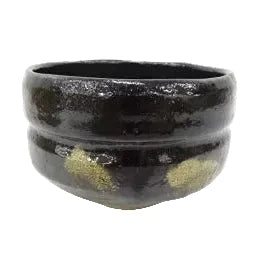 Black ceramic bowl with gold accents on a white background
