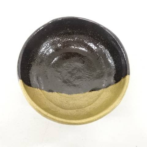 Black and gold ceramic dish on a white background