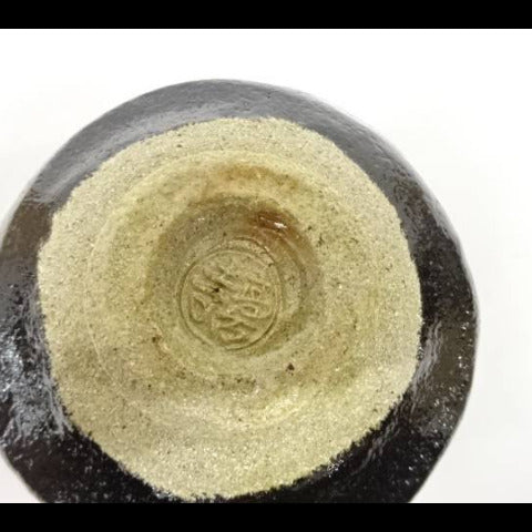 Close-up of a stone with a circular engraving on a white background