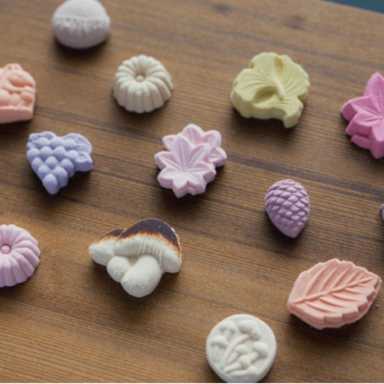 Assorted colorful candy pieces on a wooden surface