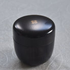 Black container with a gold emblem on a gray background