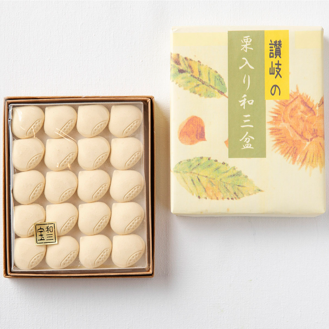Box of white cookies next to a decorative box with floral design on a light gray background