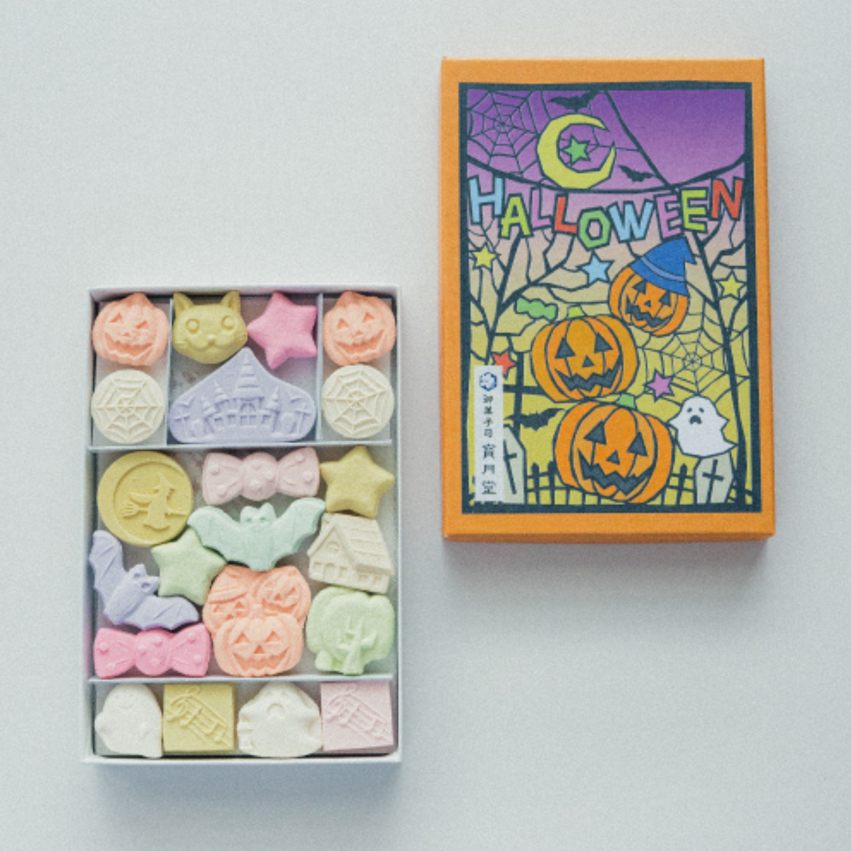 Colorful Halloween-themed candy set with a decorative box on a light gray background