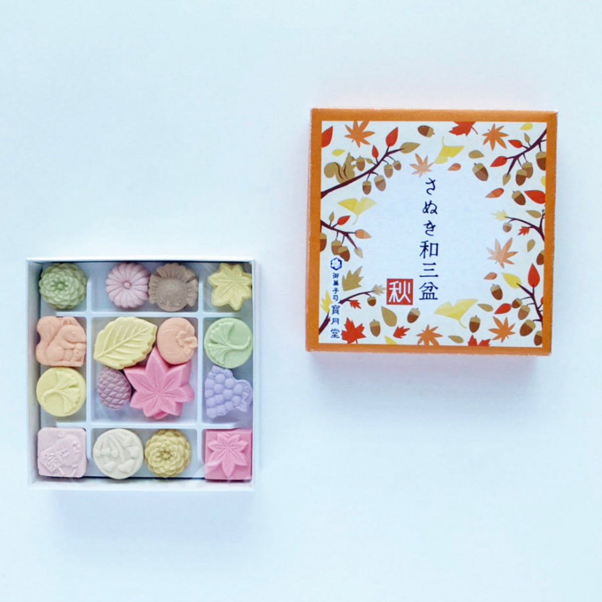 Box of colorful higashi with a decorative lid on a light gray background
