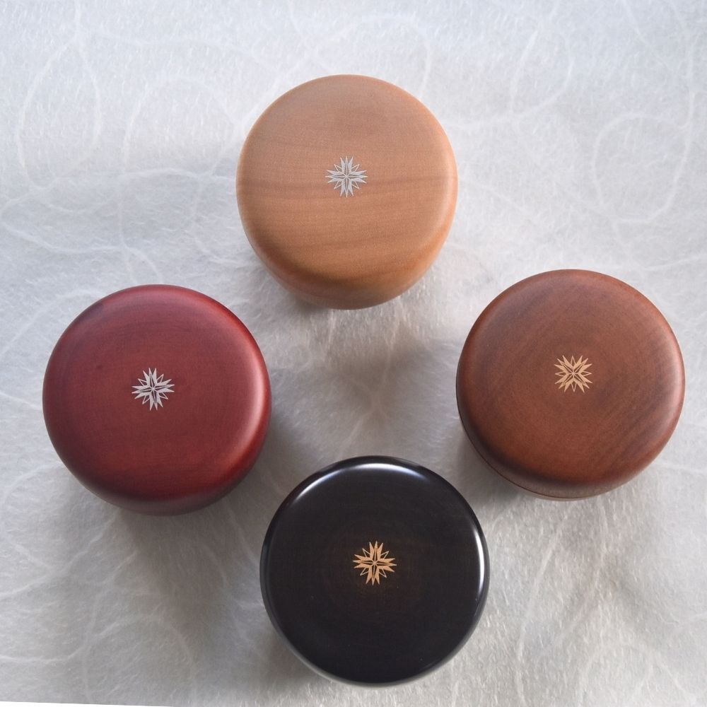 Four wooden containers with star designs on a surface
