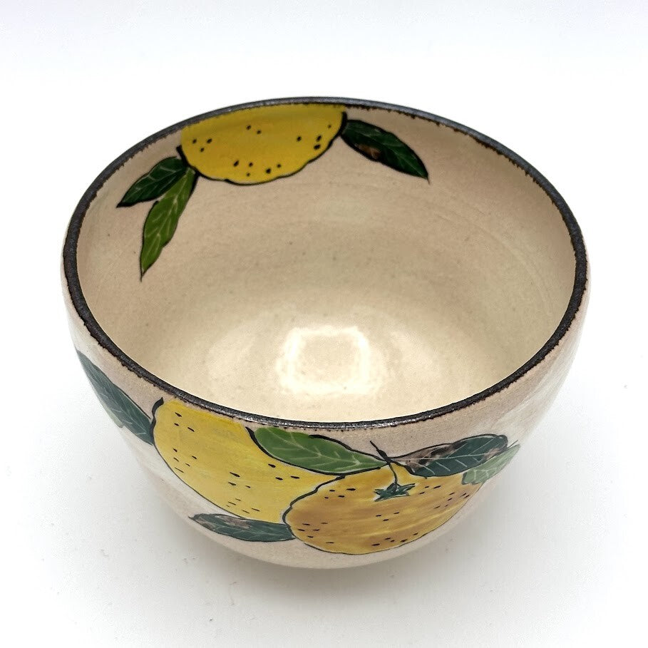Top interior view of the Kyo-yaki yuzu chawan showing its warm ivory glaze and hand-painted yellow yuzu fruit and green leaves around the rim
