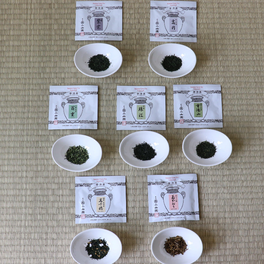 Tea leaves in small white bowls with packaging on a textured surface