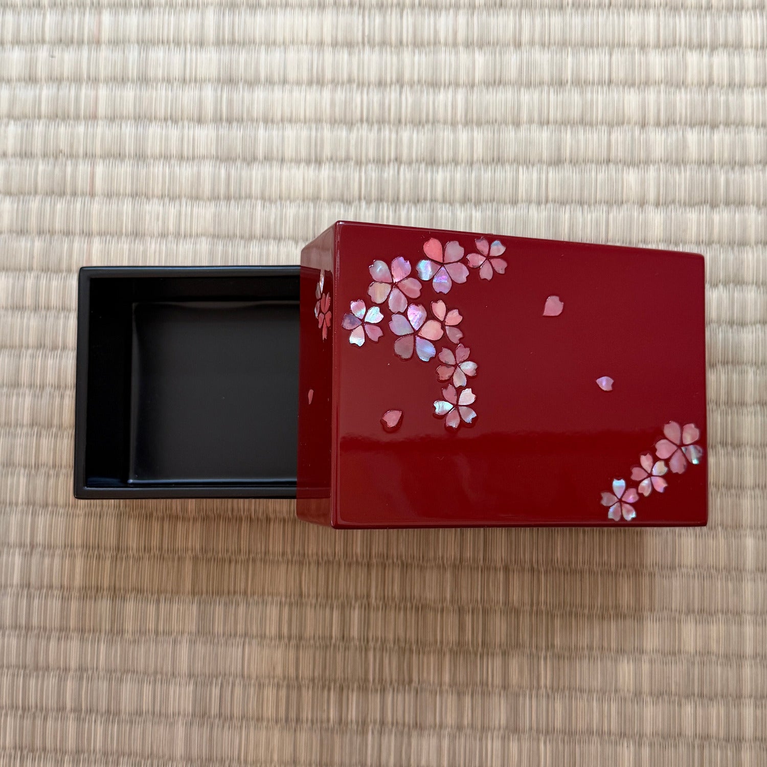 Red decorative box with floral patterns on a textured surface
