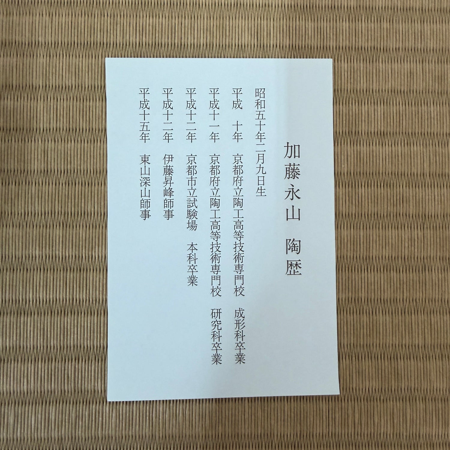 White paper with black text on a woven mat background