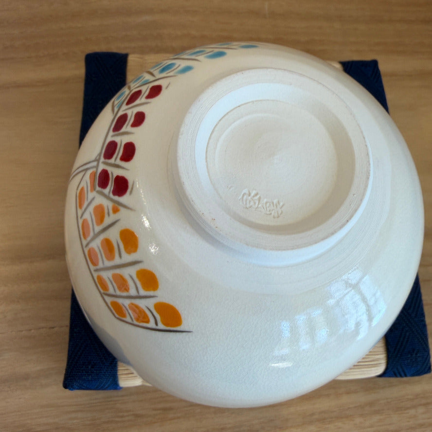 White ceramic bowl with colorful design on a wooden surface