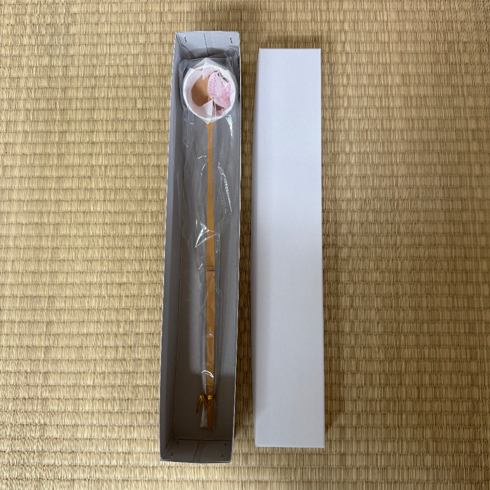 Spoon with a small container on a bamboo mat