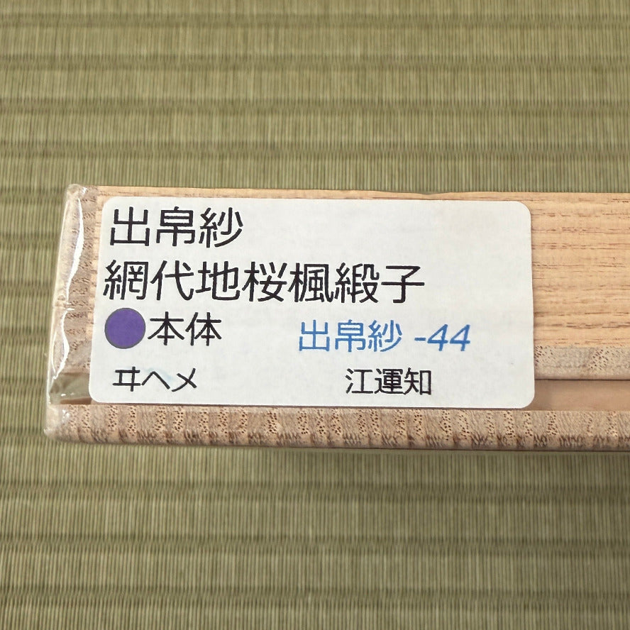 Roll of fabric with a label on a green fabric background