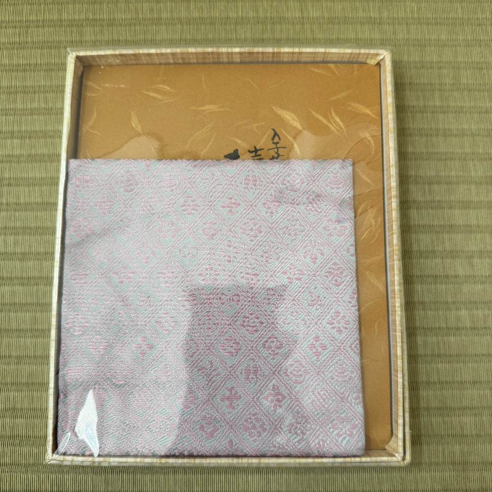 Packaged product with a gold border on a green textured background