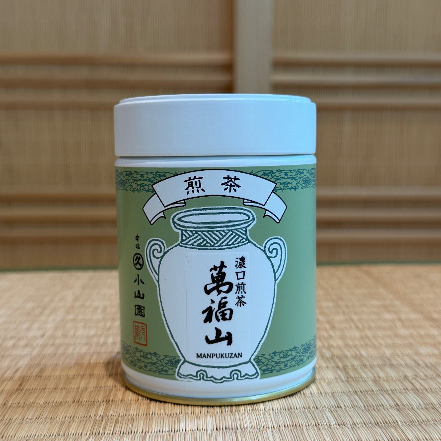 Cylindrical container with green and white design on a wooden surface