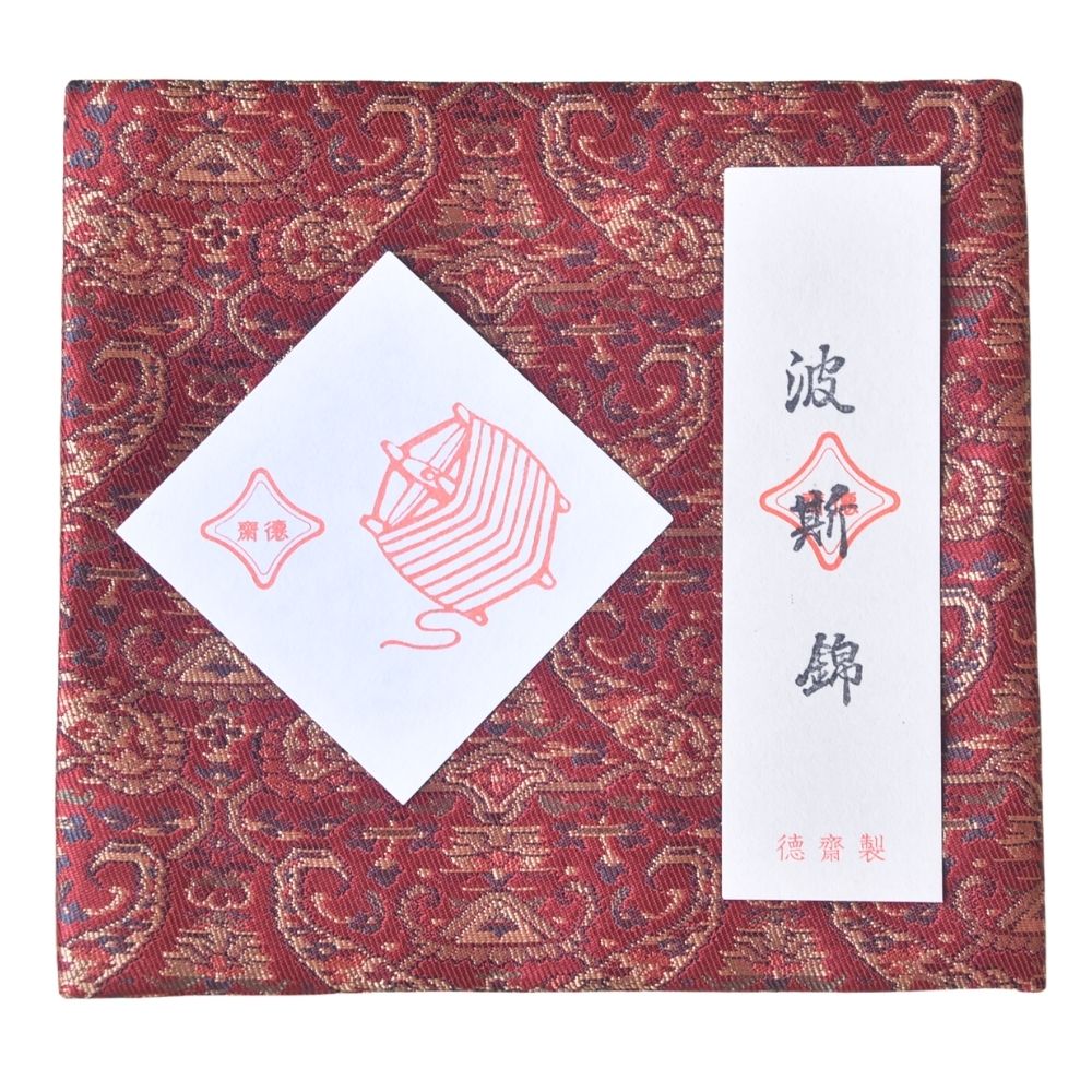 Decorative box with intricate patterns and a white card with red text on a red background