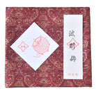 Decorative box with intricate patterns and a white card with red text on a red background