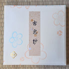 Product packaging with floral designs and text on a textured surface