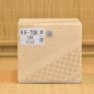 Beige box with geometric pattern and labels on a tatami surface
