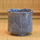 Gray ceramic cup on a woven mat background