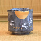 Ceramic cup with rabbit designs on a bamboo mat