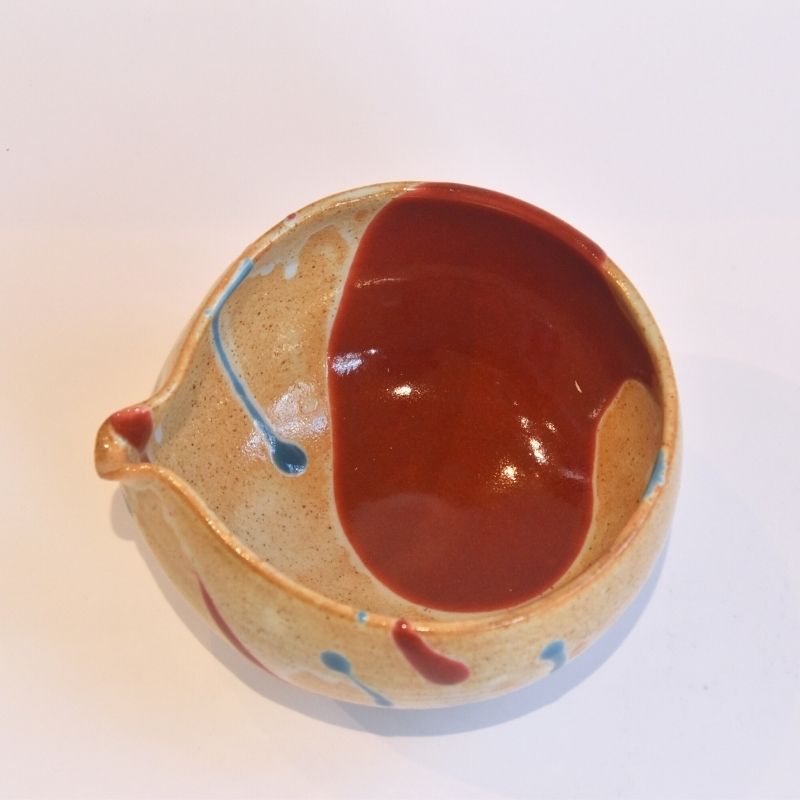 Ceramic bowl with brown interior and beige exterior on a white background