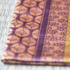 Close-up of a fabric with intricate patterns and colors on a textured surface