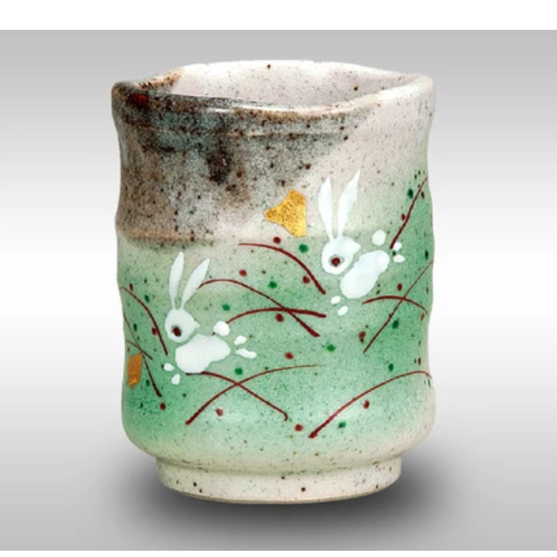 Ceramic cup with rabbit designs on a light gray background