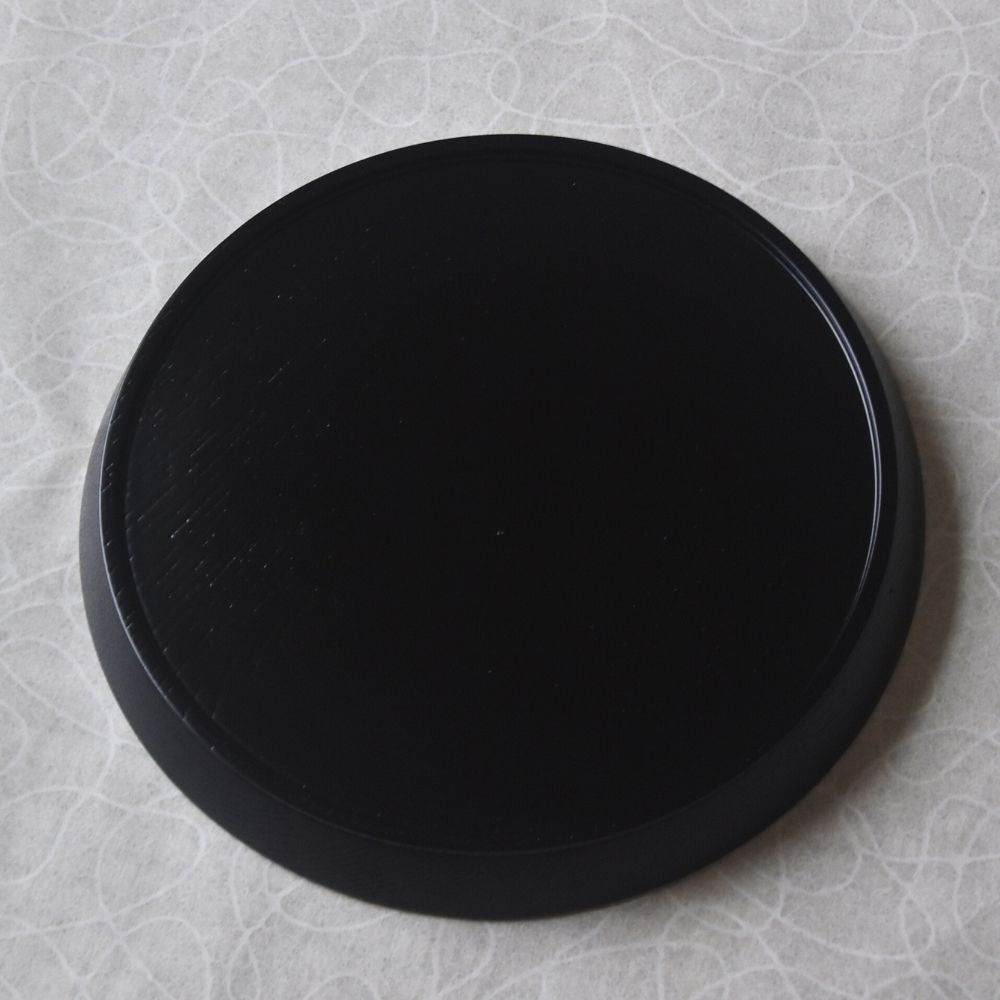 Black circular object on a textured gray surface