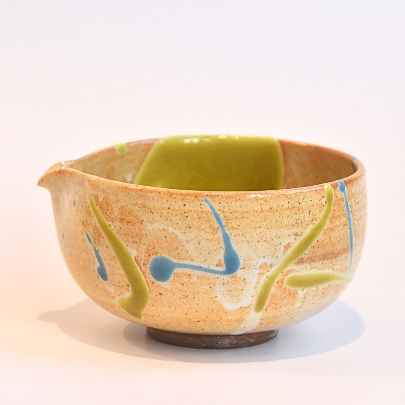 Ceramic bowl with green and blue abstract designs on a white background