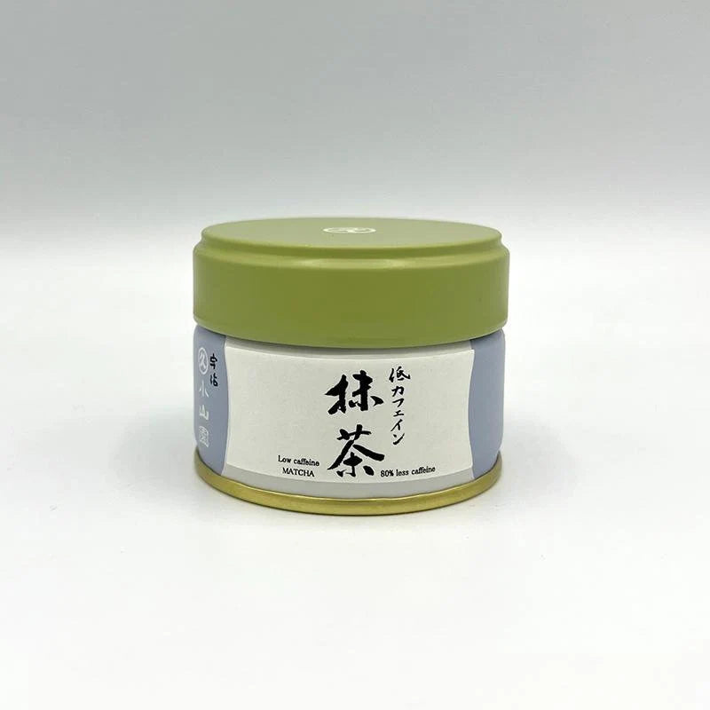 Container of matcha green tea powder with a green lid on a white background