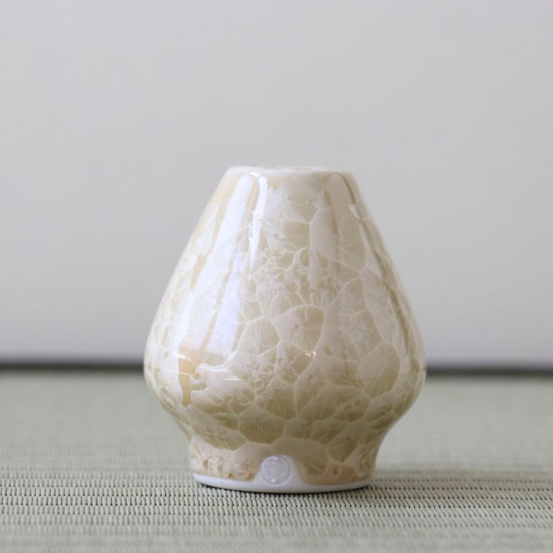 Matcha Whisk stand with textured surface on a light gray background