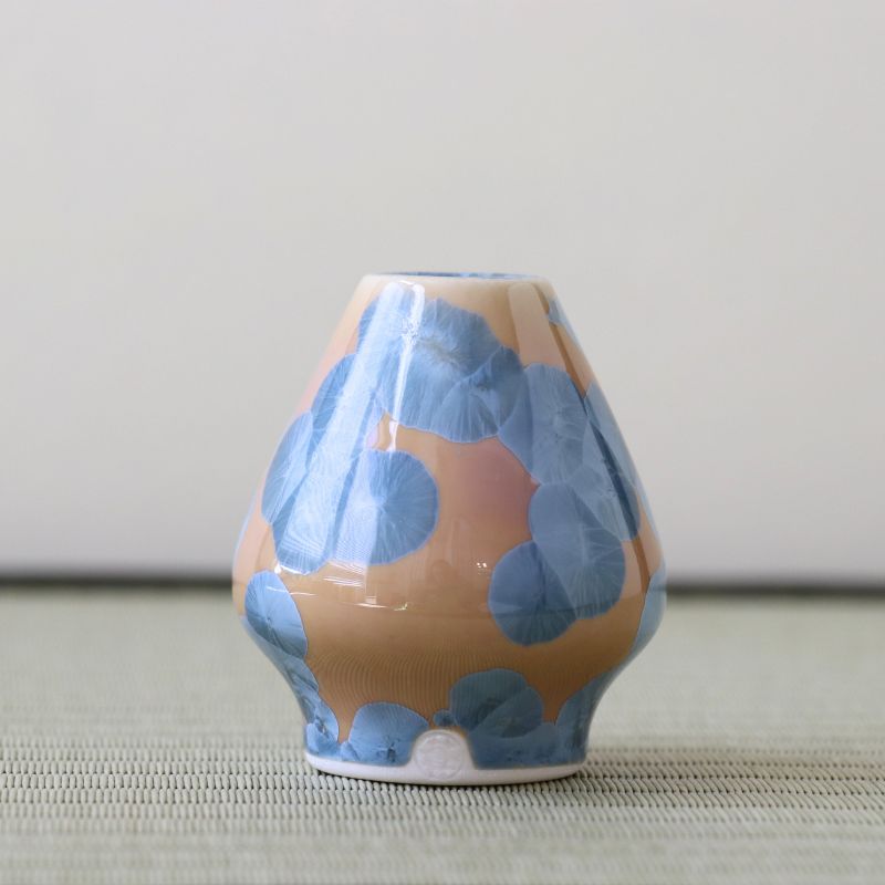 Matcha Wrisk stand with blue floral pattern on a beige background