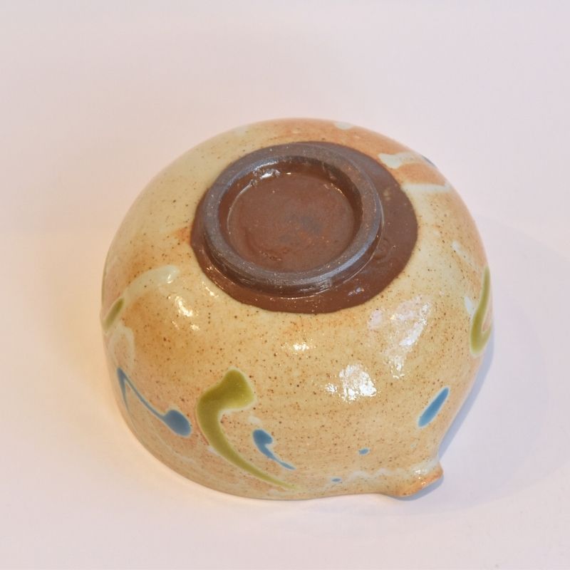 Ceramic bowl with brown interior and colorful exterior on a white background