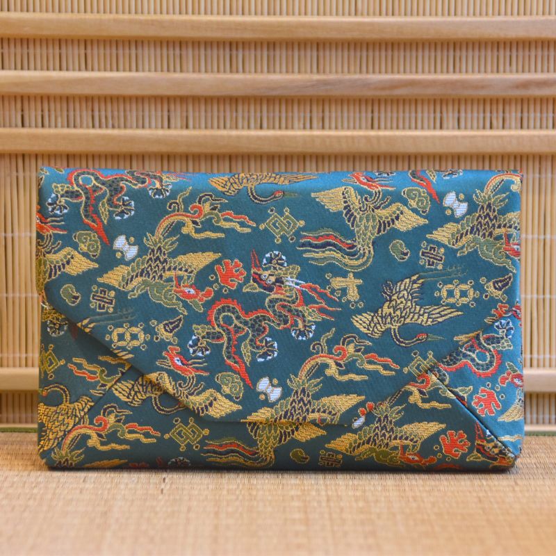 Blue clutch bag with dragon pattern on a woven background