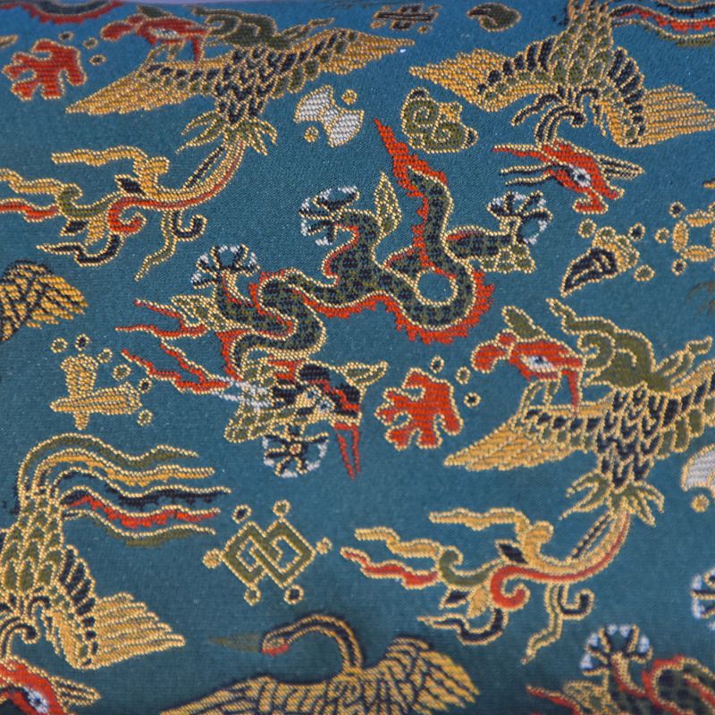 Decorative fabric with embroidered dragons on a blue background