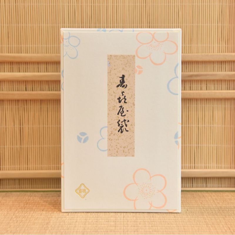 Rectangular product packaging with floral designs and text on a bamboo background