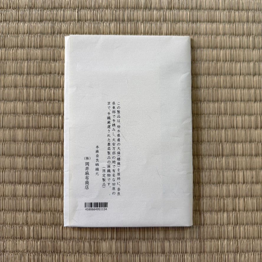 White rectangular product packaging with text on a woven mat background