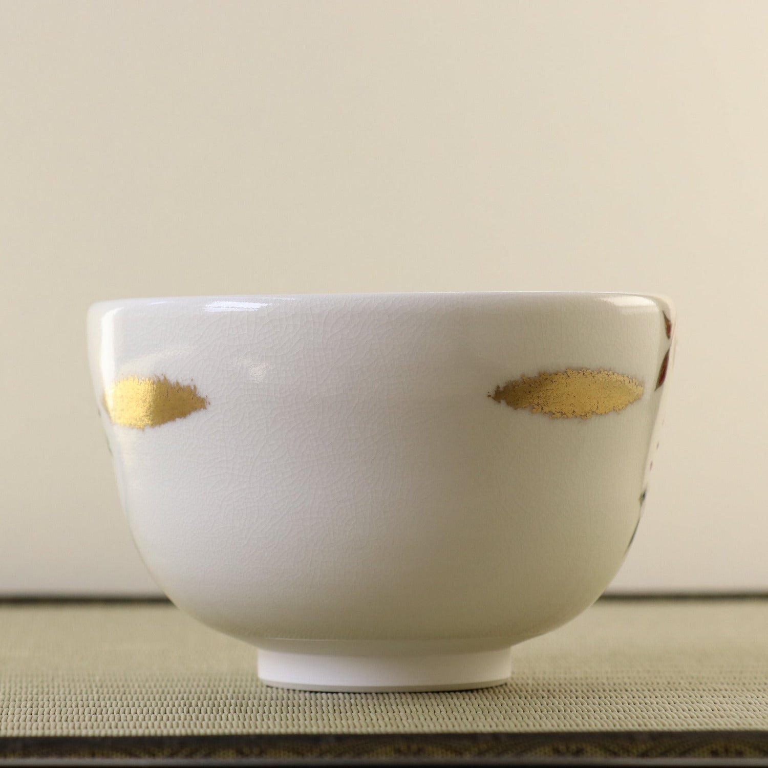 White ceramic bowl with gold accents on a neutral background