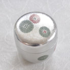 Silver container with floral patterns on a white background