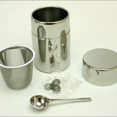 A stainless-steel matcha sifter can with a set of three round stainless-steel balls and a measuring spoon, displayed on a white background.