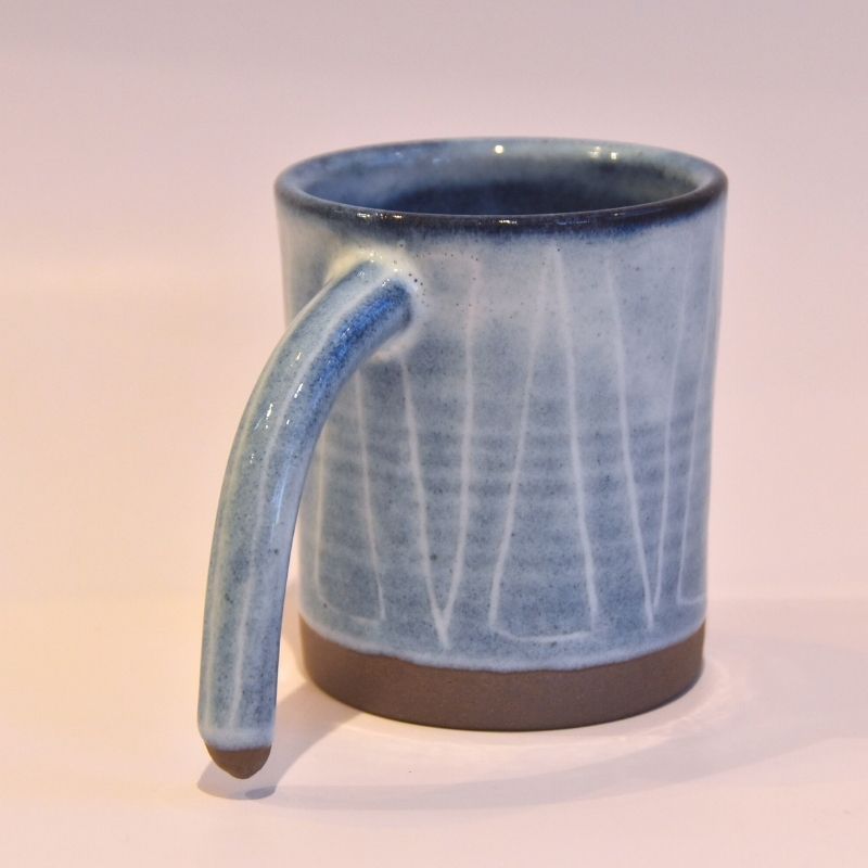 Blue ceramic mug with a handle on a white background