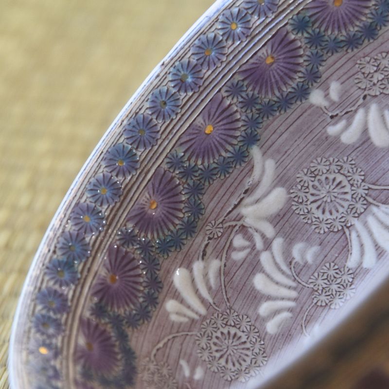 Close-up of a decorative plate with floral patterns on a textured surface