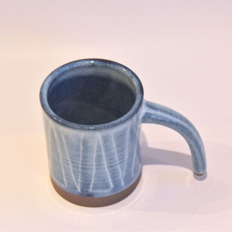 Blue ceramic mug on a light beige background